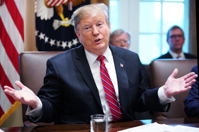 Trump gestures with both his hands out as he speaks during a cabinet meeting.
